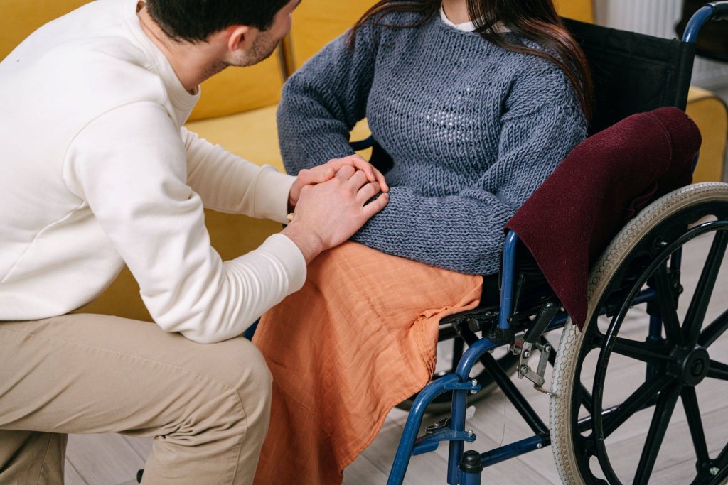 man holding wifes hand in wheelchair